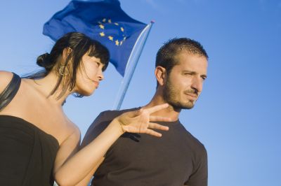 Asiatic Girl Is Talking With A Caucasic Boy Under The European Flag