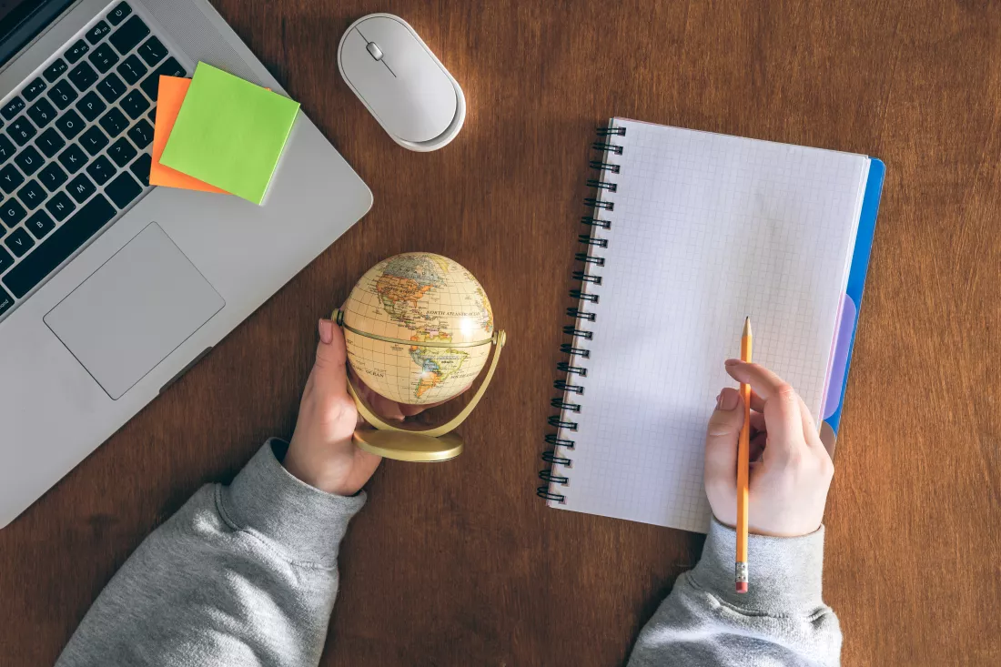 globe-hands-laptop-notepad-background-wooden-table