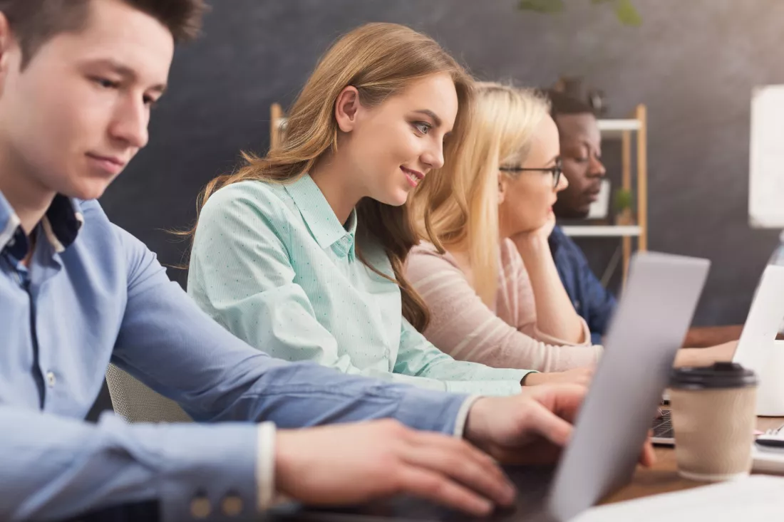 Mlodzi programisci pracuja przy laptopach w biurze