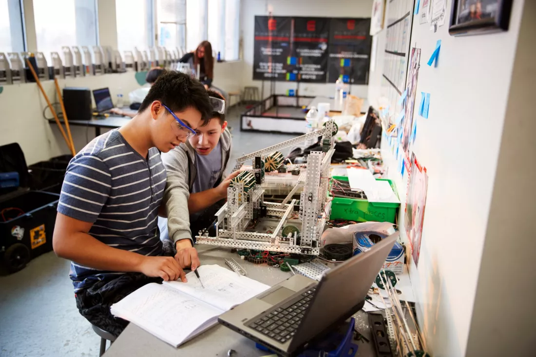Studenci inzynierii pracuja przy robocie w laboratorium
