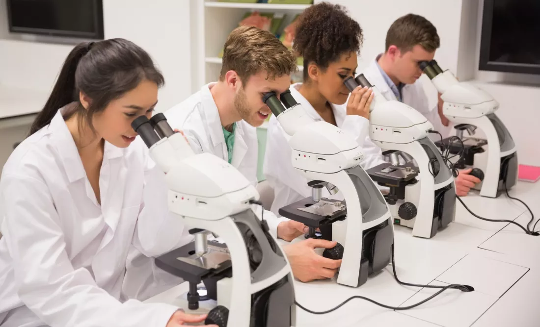 Studenci przy mikroskopach w laboratorium biologicznym
